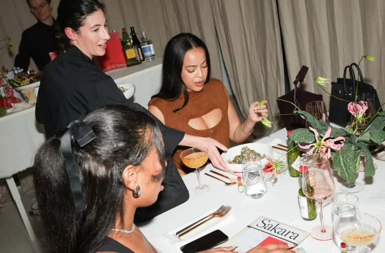Overhead shot of a dining table at an exclusive Sakara events surrounded by attendees and Sakara chefs.