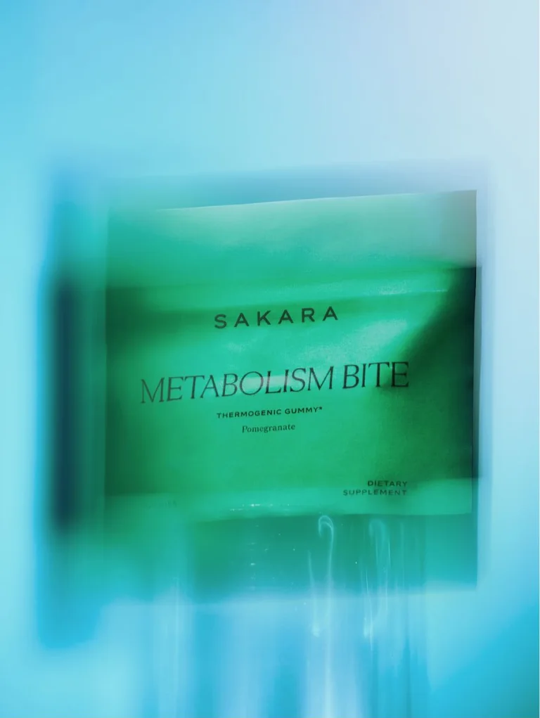 Sakara Metabolism Bite metabolism boosting gummy in bright green single-use pouch, dietary supplement, shown against a blue and green blurred gradient background.