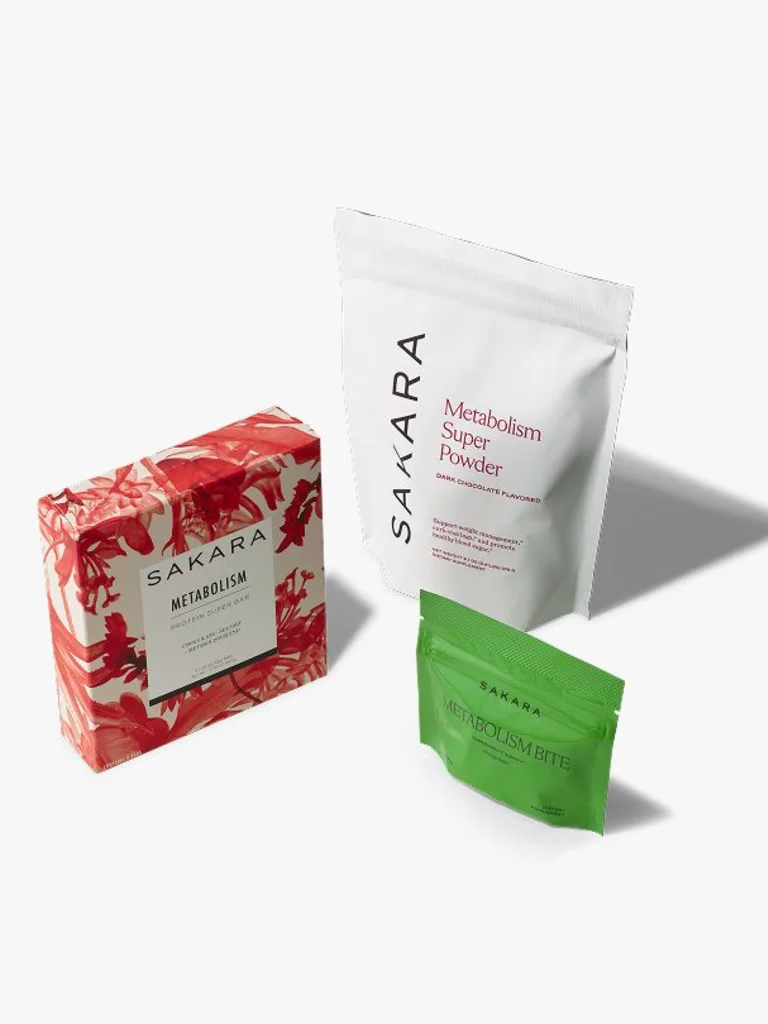 Red floral Metabolism Protein Super Bar box beside a white pouch of Metabolism Super Powder and a green pouch of Metabolism Bite gummies.