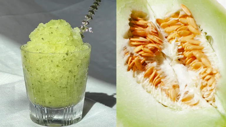 Green granita in a glass topped with mint leaves beside a halved melon showing seeds.